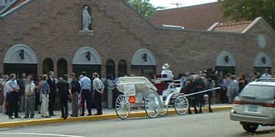 Wedding party and horse-drawn carriage outside Our Lady of the Angels church